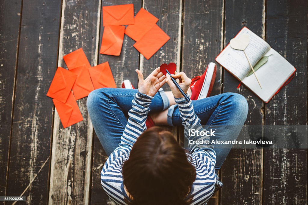 Young woman writing a valentine card - top view Writing - Activity Stock Photo