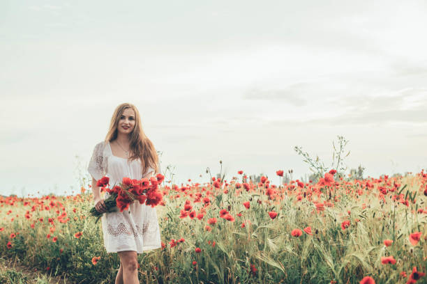 istock woman in poppy field 639025918