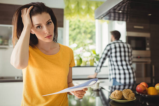istock Tensed woman checking bill in kitchen 639025980