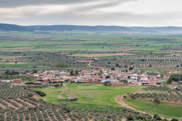 Small hamlet in an agricultural landscape in La Mancha, Ciudad Real Province, Spain. In the background can be seen the Toledo Mountains