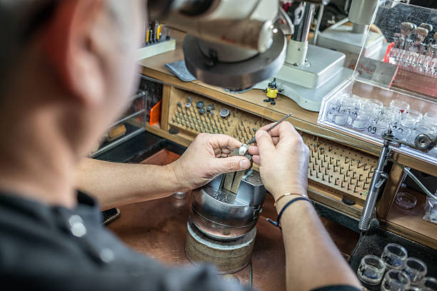 Professional gemstone settings jewellery craft laboratory: Man working with microscope