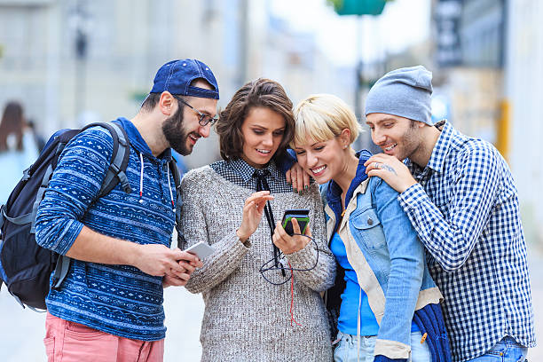 istock Friends using smart phone on street 639033002