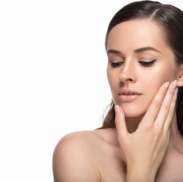 istock Young beautiful woman face portrait  touching her face. Studio shot. 639034574