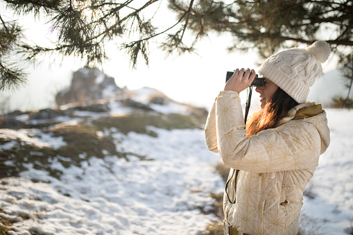 woman hiker looking into binoculars
