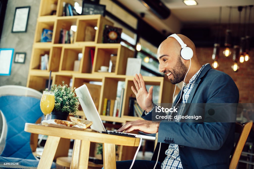 Businessman in a cafe at breakfast making video call Businessman in a cafe at breakfast making video call with laptop Cafe Stock Photo