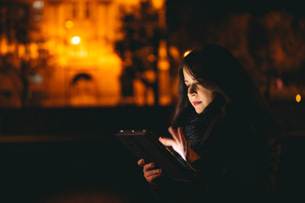 istock Young girl using tablet in the city at night 639037124