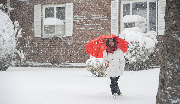 teenager-mädchen mit regenschirm unter schneefall auf der straße - queens head stock-fotos und bilder