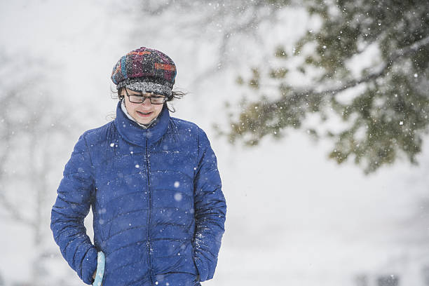 teenager-mädchen unter schneefall auf der straße - queens head stock-fotos und bilder