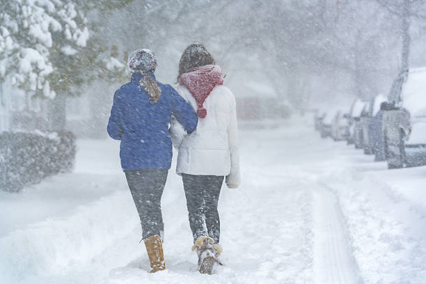 dwie nastolatki dziewczyny na śniegu w street - queens head zdjęcia i obrazy z banku zdjęć