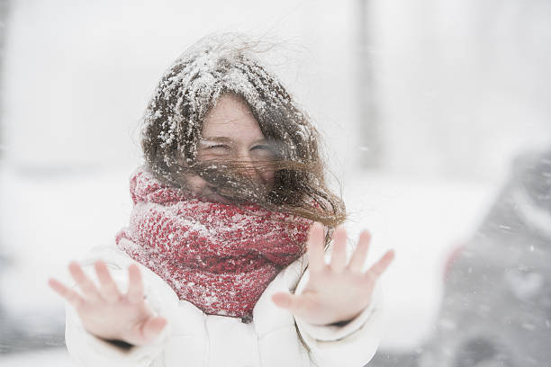 teenager-mädchen unter schneefall auf der straße - queens head stock-fotos und bilder