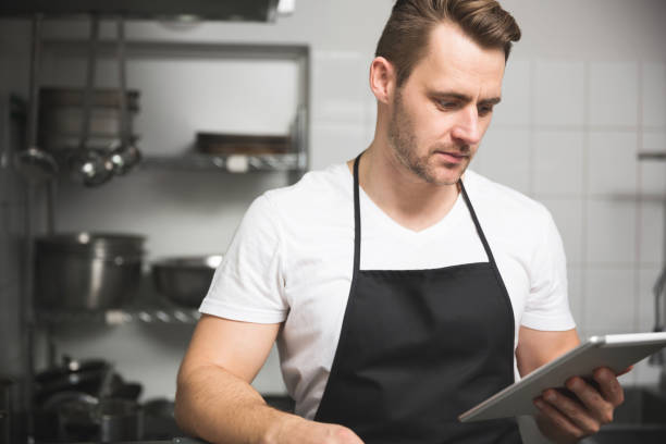 istock Handsome chef cooking meal holding tablet 639039034