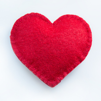 Valentine's day card. Red felt heart on white background. Top view. Isolated.