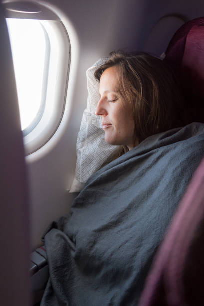 Female passenger sleeping covered with blanket. stock photo