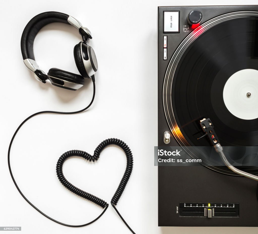 Vinyl Player with Headphones and Cord Shaped of Heart Professional Turntable, Vinyl Record Playing, Headphones with cord Shaped of Heart. Arts Culture and Entertainment Stock Photo