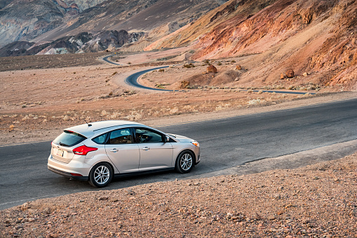 Furnace Creek, USA - September 11, 2016: A silver colored Ford Focus compact car parked on a road in Death Valley National Park, California.