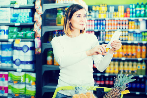 istock female customer looking at notes in shopping list 639047452