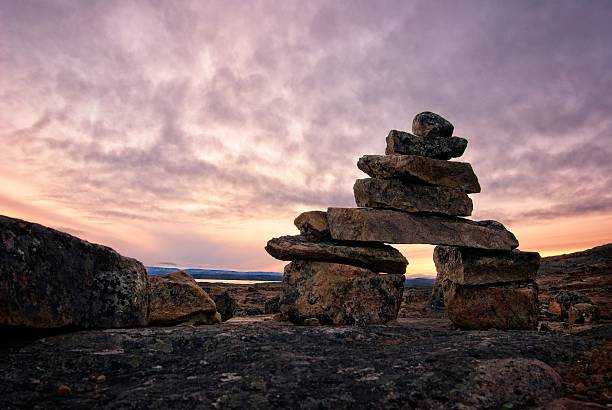 Inukshuk on Baffin Island, Nunavut, Canada.  Could be sunrise or sunset with great copy space.  Dramatic sky.