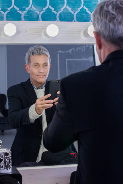 istock American Man with phone Looking Into The Mirror shooting himsels 639050118