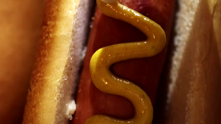 Preparing Hot Dog with Mustard and Ketchup