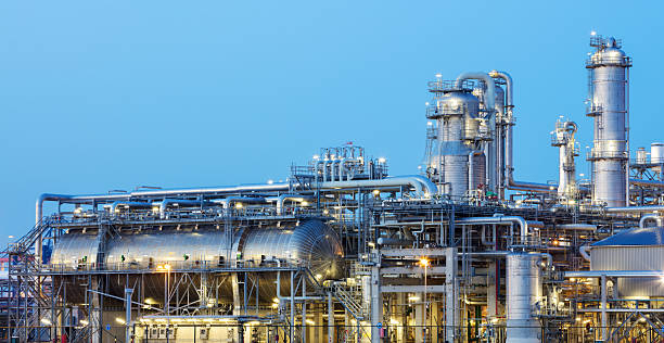 нефтеперерабатывающий завод, засветенный в сумерках - chemical plant фотографии стоковые фото и изображения