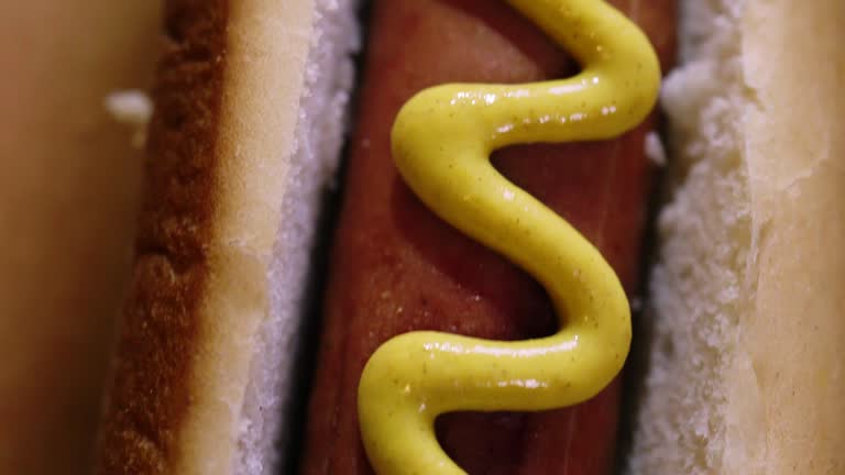 Preparing Hot Dog with Mustard and Ketchup