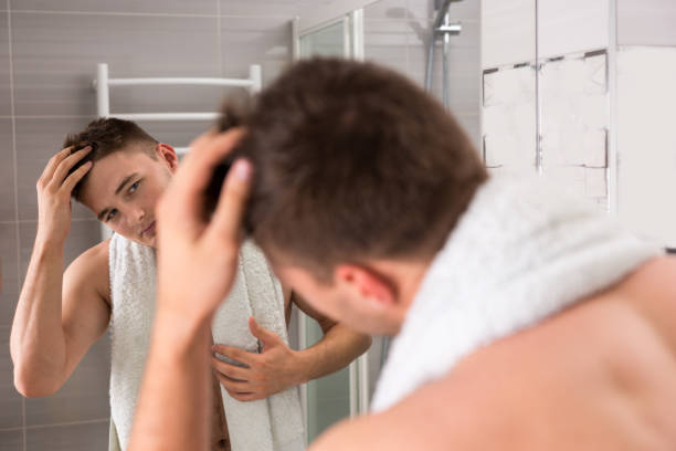 istock Young man holding towel on his shoulders while correcting hair 639055096