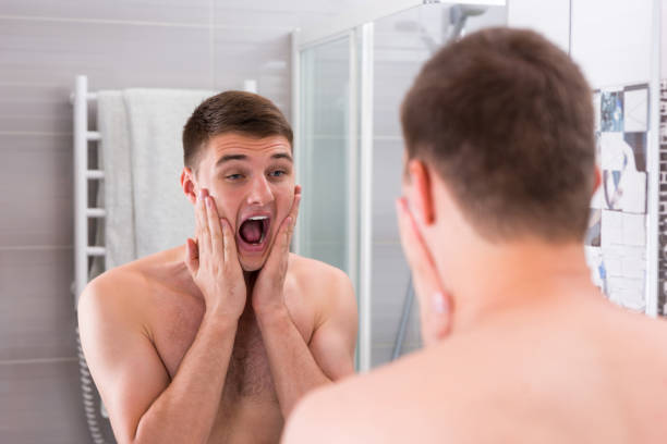 istock Young man put some aftershave lotion on a face 639055284