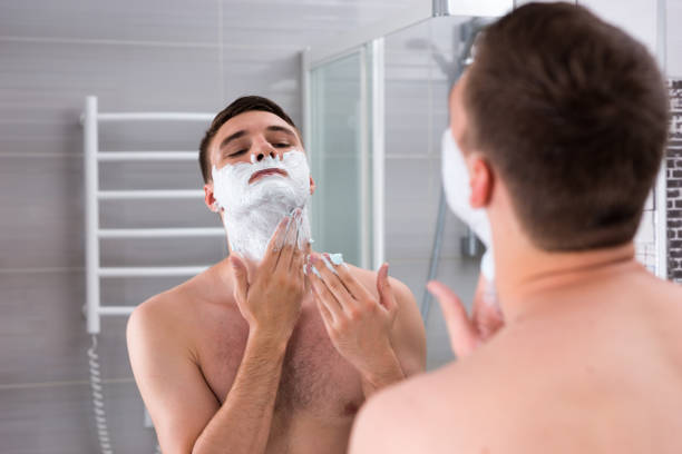 istock Young man smearing shaving gel on his face 639055510
