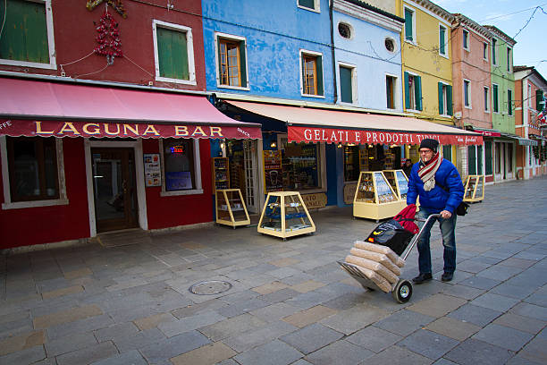 бурано, венеция, италия: человек с долли доставка поставок - vibrant color venice italy travel destinations architecture стоковые фото и изображения