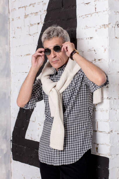 Man in shirt with pullover on shoulders in dark glasses stock photo