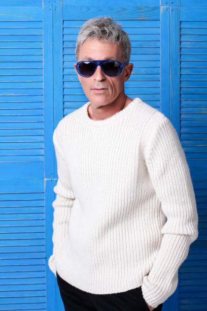 Elegant Man with blue glasses in front of blue wooden windows stock photo