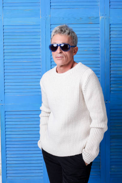 Elegant Man with blue glasses in front of blue wooden windows stock photo