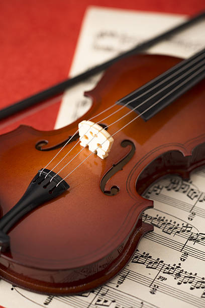 istock small toy violin on red background 639063556