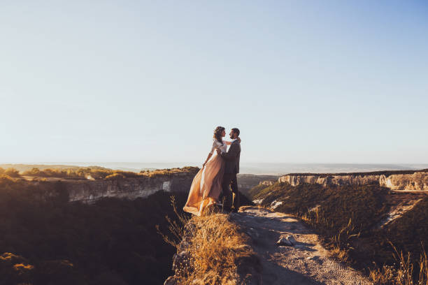 Bride and groom walking in mountains at sunset