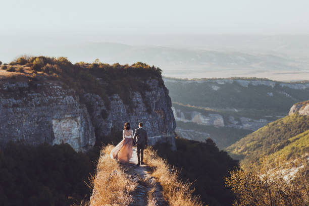 istock Bride and groom walking in mountains at sunset 639072248