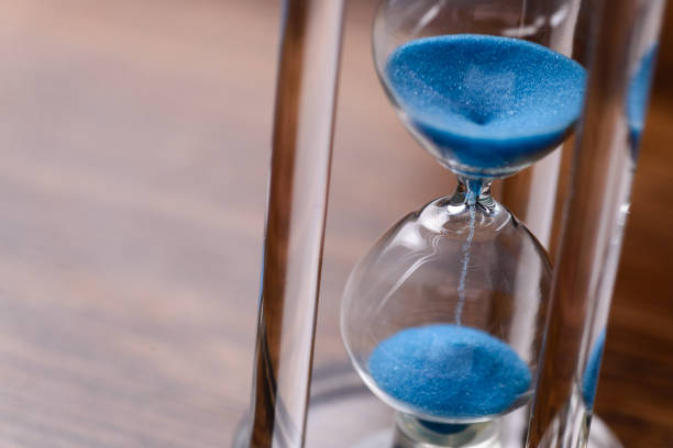 istock Classic hourglass with blue sand pouring 639079152