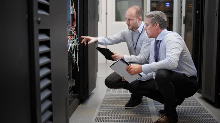 DS Two technicians squatting in the server room discussing connections