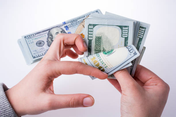 istock Human hand holding American dollar banknotes on white background 639090354