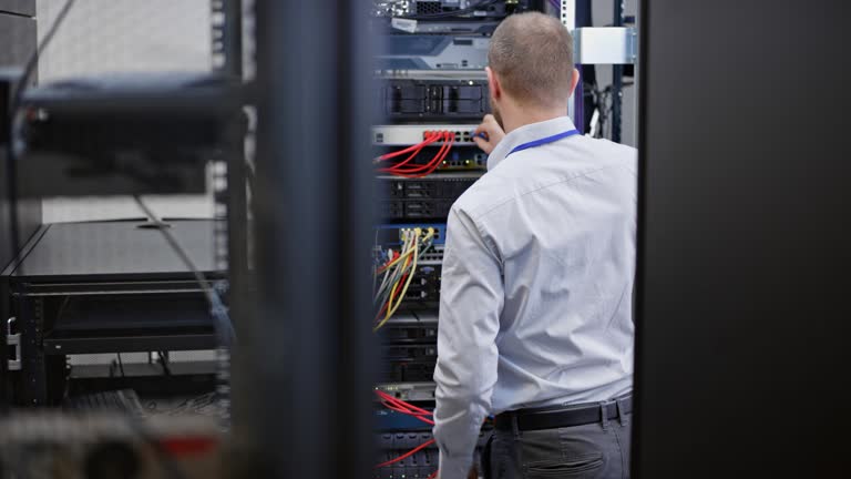 DS Male technician connecting cables in the server room