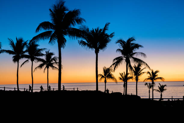 People enjoying the tropical sunset from remote Cable Beach in Broome, which is in the far north  of Western Australia. This is in the dry season, which is winter for most of the southern hemisphere, and a time when many head to Broome for winter sunshine.