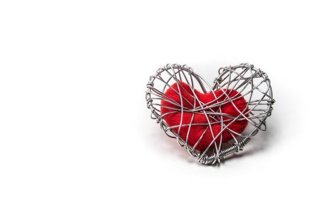 istock red fabric heart in knitted wire cage on white background 639092374