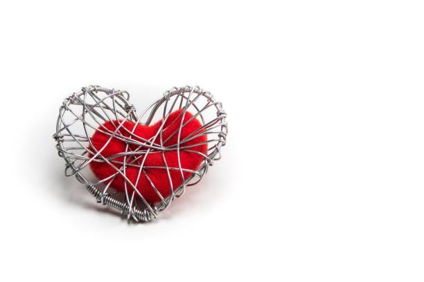 istock red fabric heart in knitted wire cage on white background 639092390