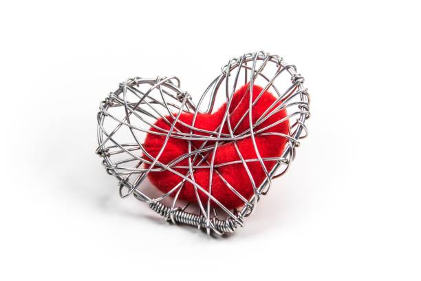 istock red fabric heart in knitted wire cage on white background 639092414