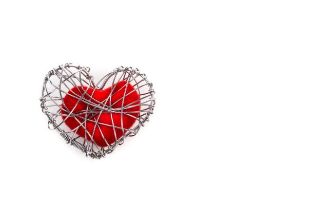 istock red fabric heart in knitted wire cage on white background 639092430