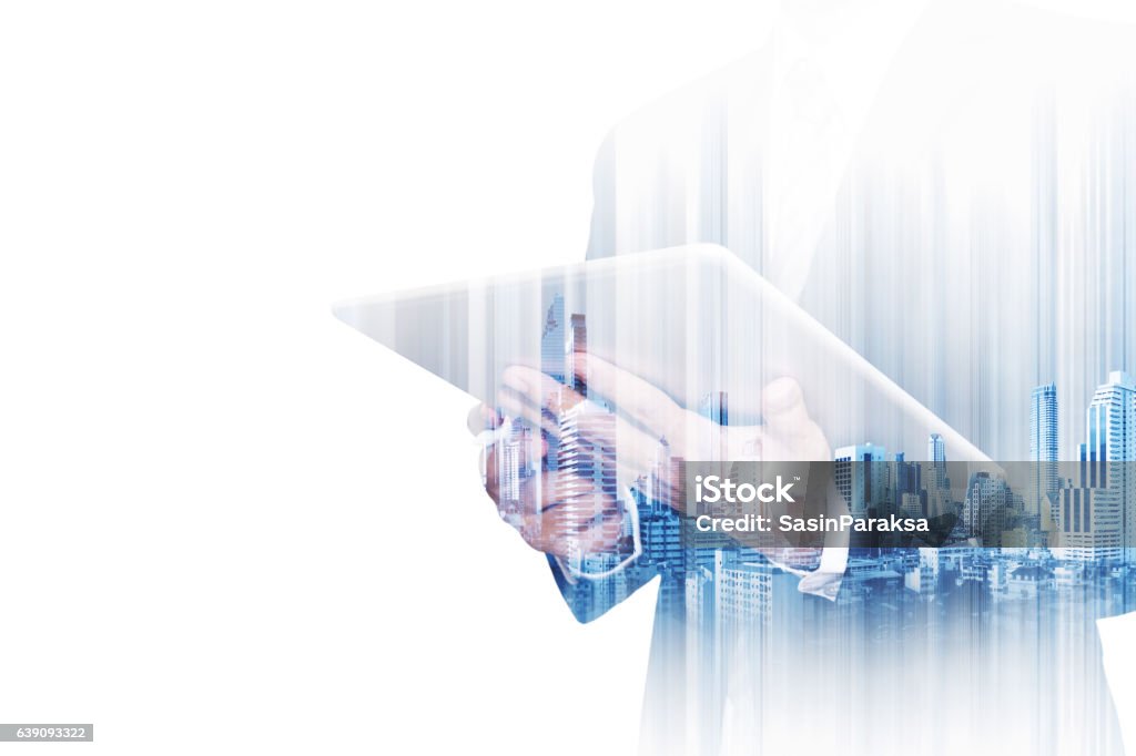 Double exposure businessman working on digital tablet with modern buildings Double exposure businessman working on digital tablet with modern buildings in the city, isolated on white background Multiple Exposure Stock Photo