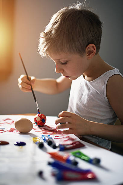 istock Little boy painting easter eggs 639096430