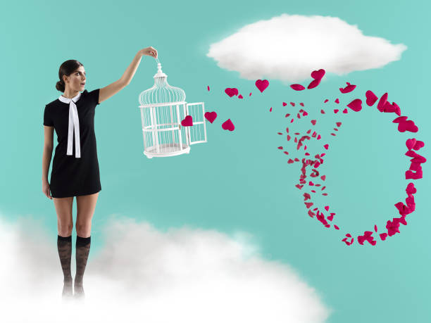 mujer de pie en la nube con jaula capturando corazones voladores. día de san valentín - women sign love trap fotografías e imágenes de stock