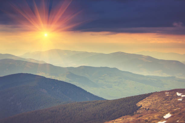 Colorful sunset in the mountains landscape. Dramatic overcast sky. Filtered image:cross processed vintage effect.