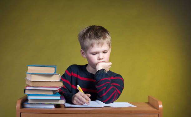 istock Unhappy Tired Little Boy Doing His Homework. Boring School Studies. 639098982