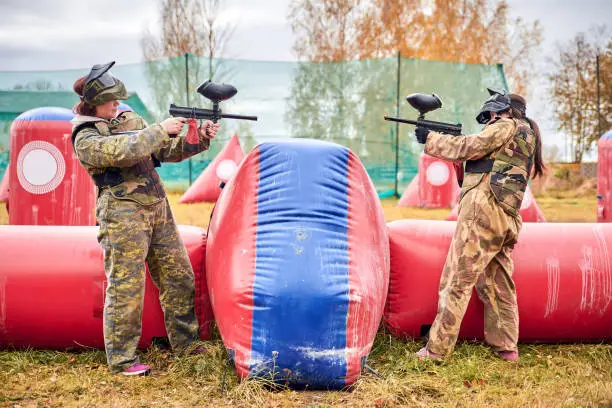 Photo of Paintball sport player girls in protective camouflage uniform